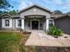 Front entrance with columns, a black door, and a patterned walkway at 12805 Sw 64Th Ln, Ocala, FL 34481