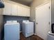 Functional laundry room features white cabinets, a shelf, washer, and dryer for convenience at 12805 Sw 64Th Ln, Ocala, FL 34481