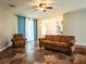 Living room with brown couches, tile floors, and view of kitchen at 12805 Sw 64Th Ln, Ocala, FL 34481