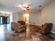 Open living room with ceiling fan, tiled floor, and dark-colored furniture at 12805 Sw 64Th Ln, Ocala, FL 34481