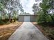 Exterior view of the metal storage building with a wide concrete driveway at 12805 Sw 64Th Ln, Ocala, FL 34481
