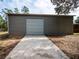 Exterior view of the metal storage building with a wide concrete driveway at 12805 Sw 64Th Ln, Ocala, FL 34481