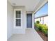 Covered front porch with gray door and window at 6014 Sw 93Rd Cir, Ocala, FL 34481