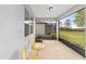 Relaxing screened porch with yellow chairs and view of backyard at 6014 Sw 93Rd Cir, Ocala, FL 34481
