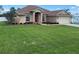 Well-maintained home with a lush lawn, stone details, and attached two-car garage at 10923 Sw 38Th Ave, Ocala, FL 34476