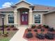 Inviting front entrance with red double doors, manicured landscaping, and a well-lit walkway at 10923 Sw 38Th Ave, Ocala, FL 34476