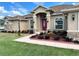 Inviting facade with a vibrant red door, stone accents, and beautifully landscaped front yard at 10923 Sw 38Th Ave, Ocala, FL 34476