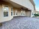 Covered patio featuring brick pavers, a ceiling fan, and views of the backyard at 10923 Sw 38Th Ave, Ocala, FL 34476