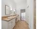 Bathroom boasting a double sink vanity, decorative lighting, and neutral tile flooring at 6042 Topsail Rd, Lady Lake, FL 32159