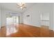 Sunlit bedroom boasts wood floors, high ceilings, sliding glass doors to a patio, and versatile layout at 6042 Topsail Rd, Lady Lake, FL 32159
