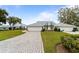 A nicely landscaped lawn with beautiful flowers and mature trees, with a lovely stone walkway leading to an attached two-car garage at 6042 Topsail Rd, Lady Lake, FL 32159