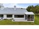 The beautiful house exterior shows the screened in patio and open patio and a well maintained lawn at 6042 Topsail Rd, Lady Lake, FL 32159