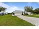 A beautiful lawn with mature trees and a lovely stone pathway leading to a home with an attached two-car garage at 6042 Topsail Rd, Lady Lake, FL 32159