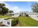 Charming single-story home with a well-manicured lawn, mature trees, and a long driveway with adjacent two-car garages at 6042 Topsail Rd, Lady Lake, FL 32159