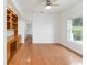 Cozy home office with hardwood floors, custom built-in shelving, and a large window providing ample natural light at 6042 Topsail Rd, Lady Lake, FL 32159
