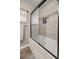 Bathroom featuring tiled walls and an alcove tub and shower with a glass enclosure at 10291 Se 42Nd Ter, Belleview, FL 34420
