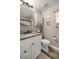 Cozy bathroom featuring granite countertops, white cabinets, and a decorative shelf above the toilet at 10291 Se 42Nd Ter, Belleview, FL 34420
