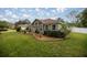 This home features a manicured lawn with lush shrubbery and garden at 10291 Se 42Nd Ter, Belleview, FL 34420