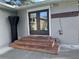 Back patio with double doors, wooden steps, and grilling area at 730 Ne 18Th Ave, Ocala, FL 34470