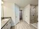 Modern bathroom with a granite-topped vanity, tiled floor, and glass-enclosed tiled shower at 8949 Se 159Th Ln, Summerfield, FL 34491