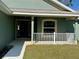 View of the front porch and front door of a quaint single Gathering home at 8949 Se 159Th Ln, Summerfield, FL 34491