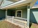 Covered front porch featuring classic white railings and complementary trim at 8949 Se 159Th Ln, Summerfield, FL 34491