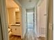 Hallway view of a full bathroom featuring granite counters and a sink at 8949 Se 159Th Ln, Summerfield, FL 34491