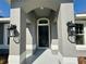 Close-up of front door with decorative columns, black hardware, and exterior lighting fixtures at 9869 Se 157Th Ln, Summerfield, FL 34491