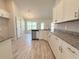 Bright kitchen features white cabinets, granite countertops, stainless steel appliances, and wood-look tile flooring at 9869 Se 157Th Ln, Summerfield, FL 34491