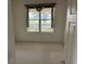 Carpeted bedroom offers a bright view with a decorative curtained window at 12576 Se 97Th Terrace Rd, Summerfield, FL 34491