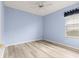 Light blue bedroom with wood-look flooring and ceiling fan at 12576 Se 97Th Terrace Rd, Summerfield, FL 34491