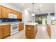 Kitchen with island, wood cabinets, and golf course view at 12576 Se 97Th Terrace Rd, Summerfield, FL 34491