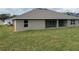 Backyard view of home with a covered patio, lawn, and a gray exterior at 7143 Sw 179Th Court Rd, Dunnellon, FL 34432