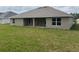 Backyard view of home with a covered patio and spacious grassy area at 7143 Sw 179Th Court Rd, Dunnellon, FL 34432