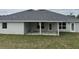 Large backyard features a covered patio, lush green lawn, and seamless indoor/outdoor living at 7173 Sw 179Th Court Rd, Dunnellon, FL 34432