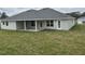 Large backyard features a covered patio, lush green lawn, and seamless indoor/outdoor living at 7173 Sw 179Th Court Rd, Dunnellon, FL 34432