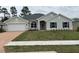 Charming one-story home with lush green lawn and a two-car garage and stone pathway at 7173 Sw 179Th Court Rd, Dunnellon, FL 34432
