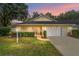 Beautiful single-story home at sunset featuring lush landscaping and a two-car garage at 9068 Sw 82Nd Ter # A, Ocala, FL 34481
