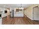 Open-concept kitchen with white cabinets, stainless steel appliances, and wood-look flooring at 9068 Sw 82Nd Ter # A, Ocala, FL 34481