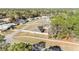 Aerial view of a home with a well-kept lawn, in a neighborhood with mature trees and quiet, paved streets at 33 Pecan Pass Run, Ocala, FL 34472