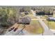 An aerial view of a home with a driveway and well-maintained lawn, surrounded by lush trees and quiet streets at 33 Pecan Pass Run, Ocala, FL 34472
