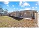 Spacious backyard with a concrete patio, partial fence, and shade trees, perfect for outdoor activities at 33 Pecan Pass Run, Ocala, FL 34472