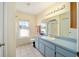 Bathroom features a large mirror, vanity, toilet, and shower with lots of light at 33 Pecan Pass Run, Ocala, FL 34472