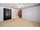 View of a bedroom with a ceiling fan, floral wallpaper border, carpet, and a dark wood closet at 33 Pecan Pass Run, Ocala, FL 34472