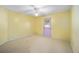 Bedroom featuring a ceiling fan, light yellow walls, and a door leading to the outside at 33 Pecan Pass Run, Ocala, FL 34472