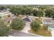 Aerial front view of a home featuring solar panels, a wide driveway, and mature trees enhancing curb appeal at 4535 Se 32Nd Pl, Ocala, FL 34480