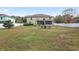 Expansive backyard with a large grassy area, a screened-in porch, and a charming fire pit sitting area at 4535 Se 32Nd Pl, Ocala, FL 34480