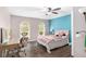 Cozy bedroom with decorative windows, ceiling fan, desk, and a pink upholstered bed at 4535 Se 32Nd Pl, Ocala, FL 34480