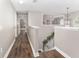 View of the upstairs hallway with wood floors, neutral paint and stairs with decorative garland at 4535 Se 32Nd Pl, Ocala, FL 34480