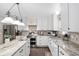 Open kitchen with white cabinets, marble counter tops, stainless appliances, large island, and hardwood floors at 4535 Se 32Nd Pl, Ocala, FL 34480